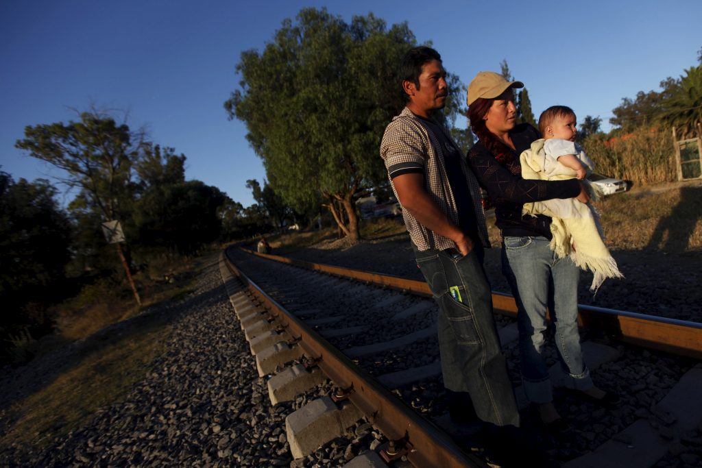 An illegal Salvadoran migrant couple is seen on railway track with their son Andrew, six months, during the arrival of the...