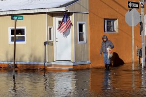 A man walks on a flooded street at Fairmount and Arizona Avenues on his way to work at a casino after a powerful snowstorm struck the U.S. East Coast, in Atlantic City, New Jersey