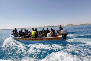 Migrants ride in a boat after they were rescued by Libyan coastguard off the coast of Gharaboli, east of Tripoli