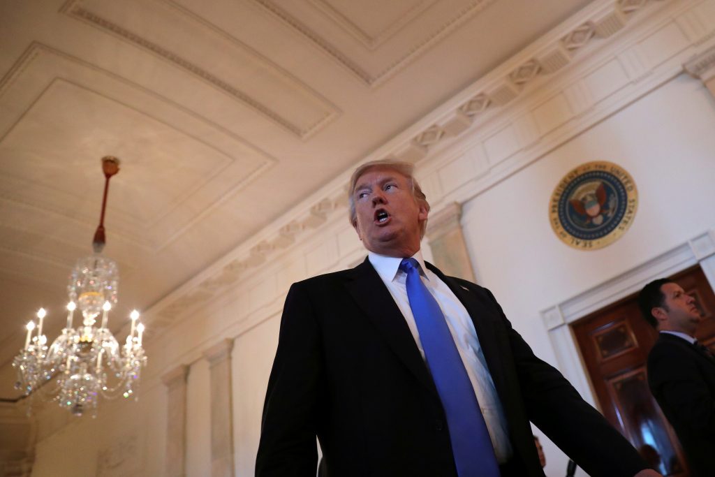 U.S. President Donald Trump reacts as he leaves a Made in America roundtable meeting in the East Room of the White House i...