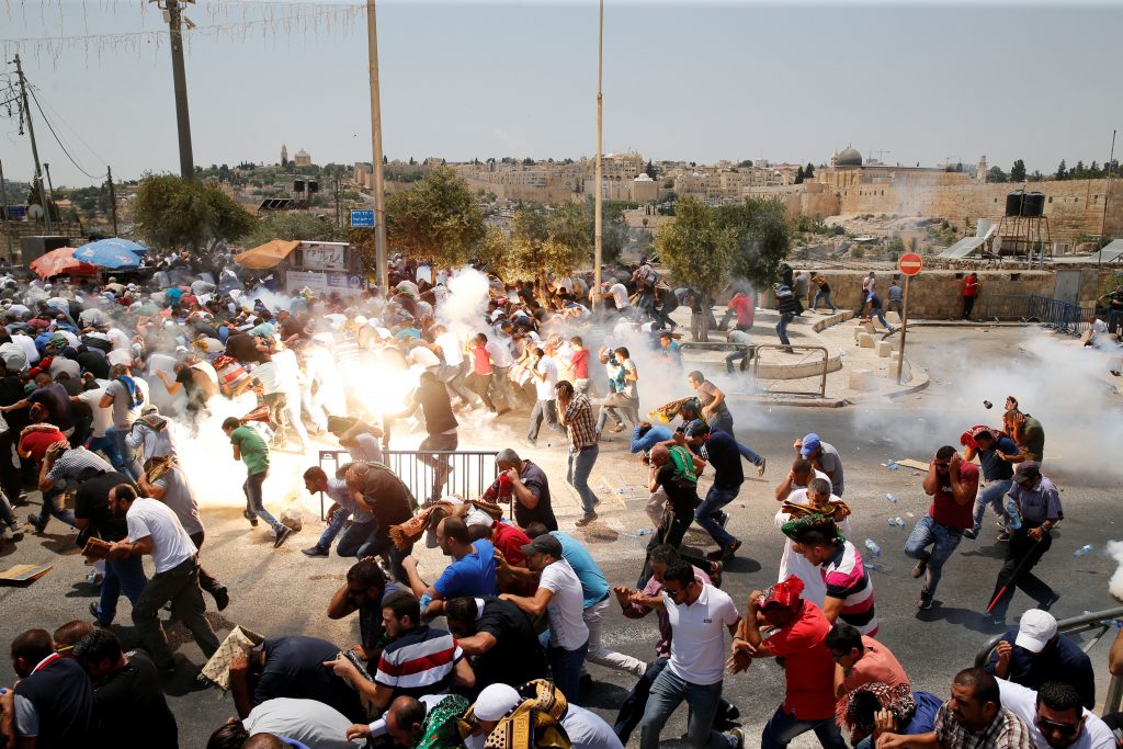 Palestinians react following tear gas that was shot by Israeli forces after Friday prayer on a street outside Jerusalem's Old city July 21, 2017. Photo by Ammar Awad and Reuters