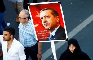 A woman holds a portrait of Turkey's President Tayyip Erdogan during a ceremony marking the first anniversary of the attempted coup at the Bosphorus Bridge in Istanbul