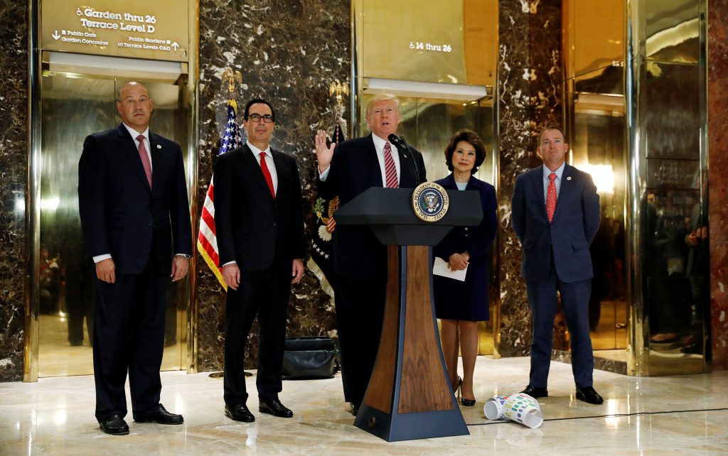 U.S. President Donald Trump is flanked by (L-R) Director of the National Economic Council Gary Cohn, Treasury Secretary Steven Mnuchin, Secretary of Transportation Elaine Chao and Director of the Office of Management and Budget Mick Mulvaney as he speaks about the violence, injuries and deaths at the "Unite the Right" rally in Charlottesville while talking to the media in the lobby of Trump Tower in Manhattan, New York, U.S., August 15, 2017. REUTERS/Kevin Lamarque - RTS1BXQL