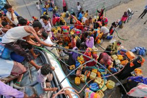People surround a tanker of water to fill their jerry cans during Yemen's cholera outbreak. Photo by Abduljabbar Zeyad/Reuters