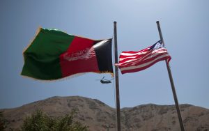 FILE PHOTO - An Afghan flag flutters next to a U.S. flag as a U.S Chinook helicopter flies during a security handover ceremony in Panjshir province