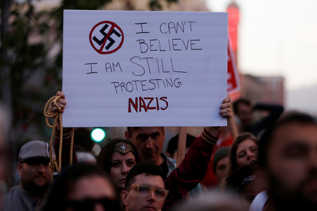 Demonstrator holds signs during a rally in response to the Charlottesville, Virginia car attack in Oakland