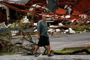 A man walks past a business which was left damaged after Hurricane Harvey hit Rockport
