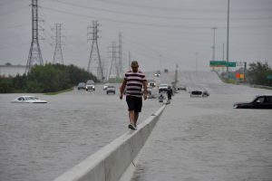 A stranded motorist escapes floodwaters on Interstate 225 after Hurricane Harvey inundated the Texas Gulf coast with rain causing mass flooding