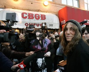 New York, UNITED STATES: Rock star and poet Patti Smith (R) comes outside to take pictures of CBGB, New York's most famous punk bar on its closing night 15 October 2006 after 33 years. Smith was the final performer in the club, that was closed after a homeless advocacy group that owns the property, the Bowery Residents Committee, would not renew CBGB's lease. AFP PHOTO Timothy A. CLARY (Photo credit should read TIMOTHY A. CLARY/AFP/Getty Images)