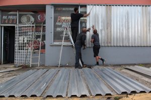 Men cover the windows of a car parts store in preparation for Hurricane Irma in San Juan, Puerto Rico September 5, 2017.  Photo by Alvin Baez/REUTERS