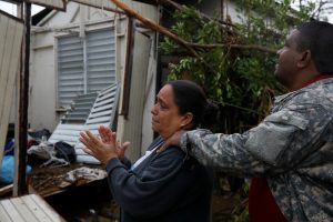 A woman reacts while she looks at the damages in the house of her mother after the area was hit by Hurricane Maria in Guayama