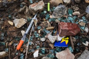 Broken glass and a discarded needle are seen near a heroin encampment in the Kensington neighborhood of Philadelphia, Pennsylvania, on April 7, 2017.