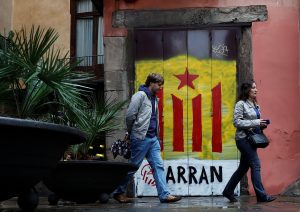 People walk past a doorway painted in the colors of the Catalan separatist flag in Barcelona, Spain, on Oct. 19. Photo by Gonzalo Fuentes/Reuters