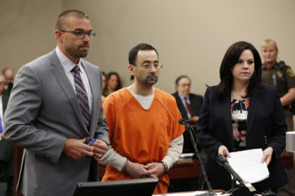Former Michigan State University and USA Gymnastics doctor Larry Nassar (C) addresses the court with his defense attorneys Matt Newberg (L) and Shannon Smith (R) in Ingham County Circuit Court on November 22, 2017 in Lansing, Michigan. Former USA Gymnastics team doctor Lawrence (Larry) Nassar, accused of molesting dozens of female athletes over several decades, on Wednesday pleaded guilty to multiple counts of criminal sexual conduct. Nassar -- who was involved with USA Gymnastics for nearly three decades and worked with the country's gymnasts at four separate Olympic Games -- could face at least 25 years in prison on the charges brought in Michigan. / AFP PHOTO / JEFF KOWALSKY (Photo credit should read JEFF KOWALSKY/AFP/Getty Images)
