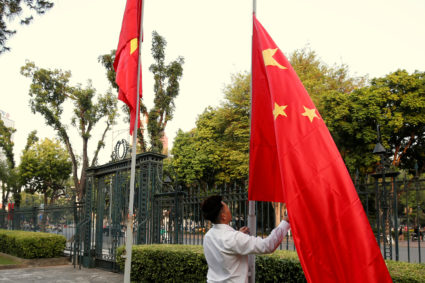 A man raises a Chinese flag next to a Vietnamese flag in Hanoi, Vietnam, on Nov. 2. Photo by Kham/Reuters