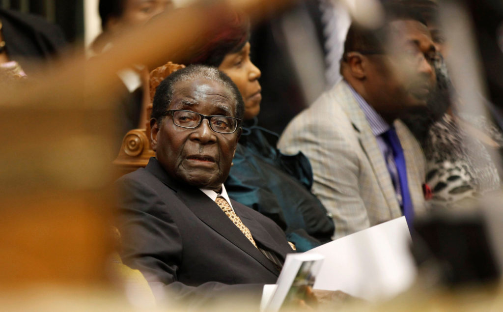 FILE PHOTO: File photo of Zimbabwe's President Mugabe listening as FM Chinamasa presents the country's 2014 National Budge...