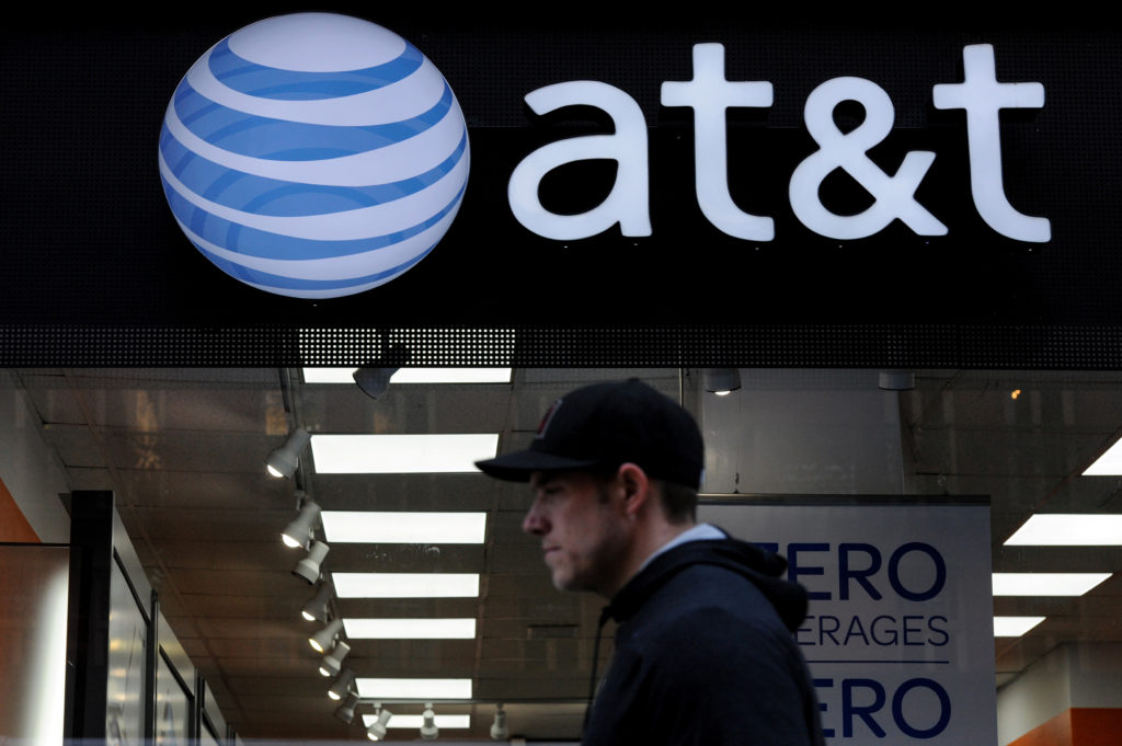 A man walks past an AT&T store in New York City, October 23, 2016. REUTERS/Stephanie Keith - S1AEUIREZRAB