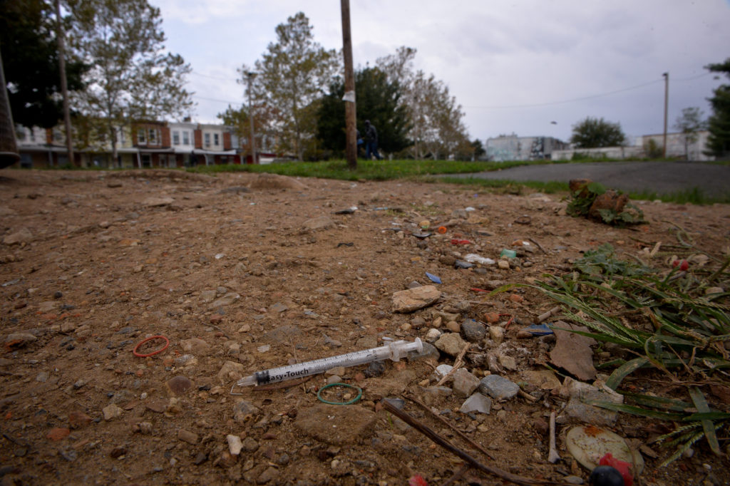 A needle used for shooting heroin and other opioids litters the ground in a park in the Kensington section of Philadelphia...