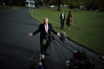 U.S. President Donald Trump talks with the reporters as First Lady Melania Trump and her son Barron wait for him while departing the White House for Palm Beach, in Washington D.C., U.S. November 21, 2017. REUTERS/Carlos Barria - RC16C8622E00