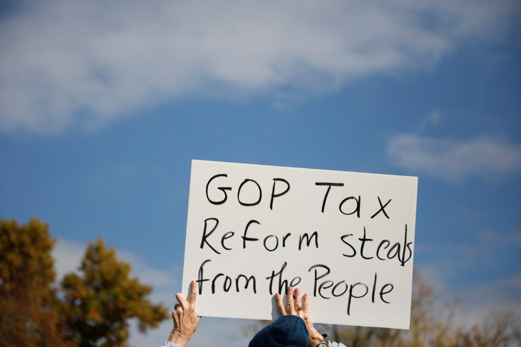 A demonstrator holds a sign during a rally against the Republican tax bill on Capitol Hill in Washington, U.S., November 1...