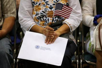 An attendee holds her new country's flag and her naturalization papers as she is sworn in during a 2017 U.S. citizenship ceremony in Los Angeles. Photo by Mike Blake/Reuters