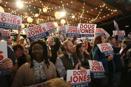 Supporters of Democratic Alabama U.S. Senate candidate Doug Jones listens to Jones as he speaks at a rally at Old Car Heaven in Birmingham, Alabama, U.S. December 11, 2017. REUTERS/Marvin Gentry - RC154BFE04B0