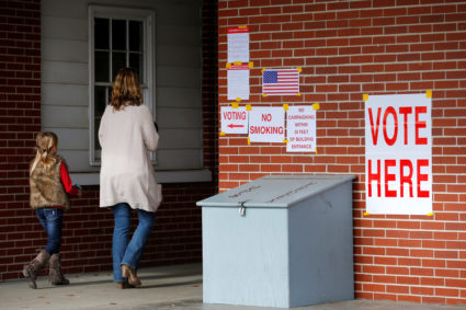 Anna Atkinson walks into a polling station with her 8-year-old daughter Tori, in Gallant, Alabama, U.S., December 12, 2017. REUTERS/Jonathan Bachman - RC1313494170
