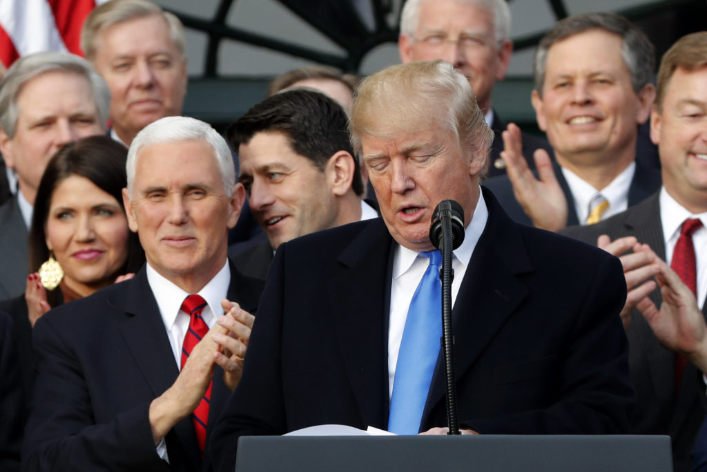Vice President Mike Pence applauds U.S. President Donald Trump as they celebrate passage of sweeping tax overhaul legislat...