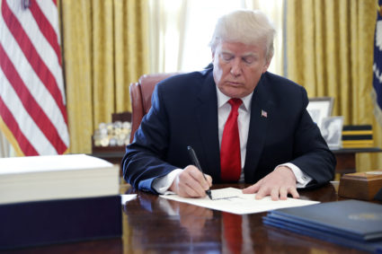 U.S. President Donald Trump signs the $1.5 trillion tax overhaul plan into law in the Oval Office of the White House on December 22, 2017. Photo by Jonathan Ernst/Reuters