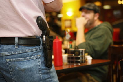 Bryan Hull, founding director of the Oklahoma Open Carry Association (OKOCA), wears an unconcealed side arm as he addresses OKOCA members gathered at Beverly's Pancake House in Oklahoma City November 1, 2012. A new Oklahoma law took effect November 1 allowing anyone with a concealed weapon license to carry their firearms openly in a holster or belt. REUTERS/Bill Waugh (UNITED STATES - Tags: SOCIETY POLITICS CRIME LAW) - GM1E8B116QY01