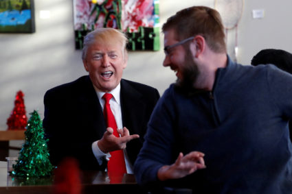 U.S. President Donald Trump reacts as retired U.S. Marine Corps Sergeant John Peck turns his wheelchair to reveal a Trump sticker and two Purple Hearts on the back at Walter Reed National Military Medical Center in Bethesda, Maryland, U.S., December 21, 2017. REUTERS/Jonathan Ernst - RC18D4178290