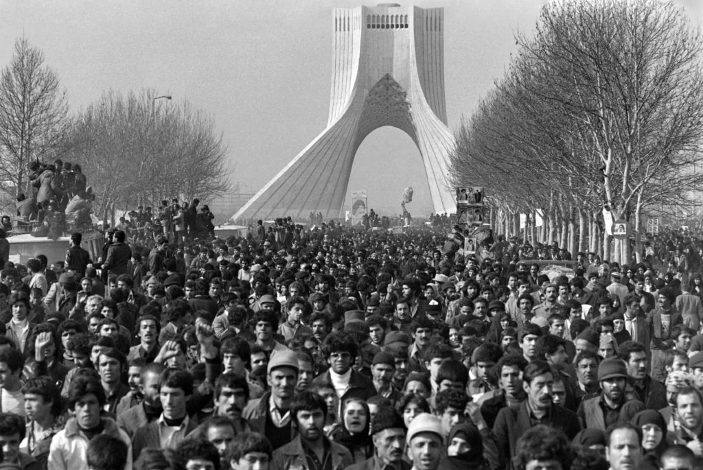 People gather at Tehran Freedom Square, formerly Monument to the Kings, to cheer the motorcade carrying Iranian opposition leader and founder of Iran's Islamic republic Ayatollah Ayatollah Ruhollah Khomeini upon his return from exile on Feb. 1, 1979 while the insurrection against the Shah's regime spreads all over the country. Photo by Gabriel Duval/AFP/Getty Images