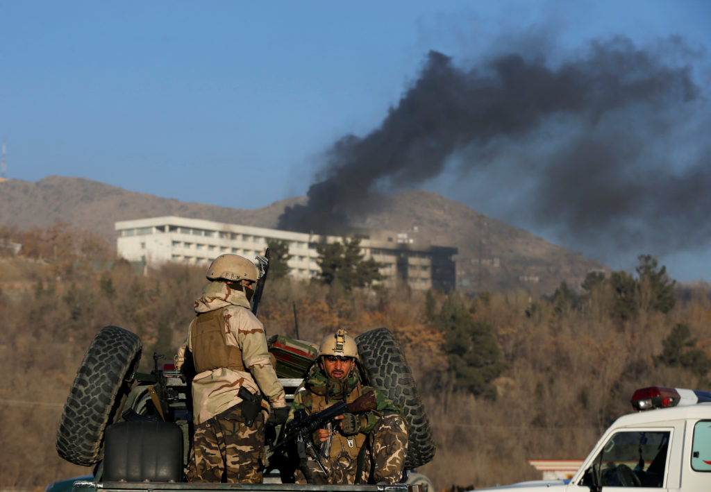 Afghan security forces keep watch as smoke rises from the Intercontinental Hotel in Kabul,ÊAfghanistanÊJanuary 21, 2018. R...