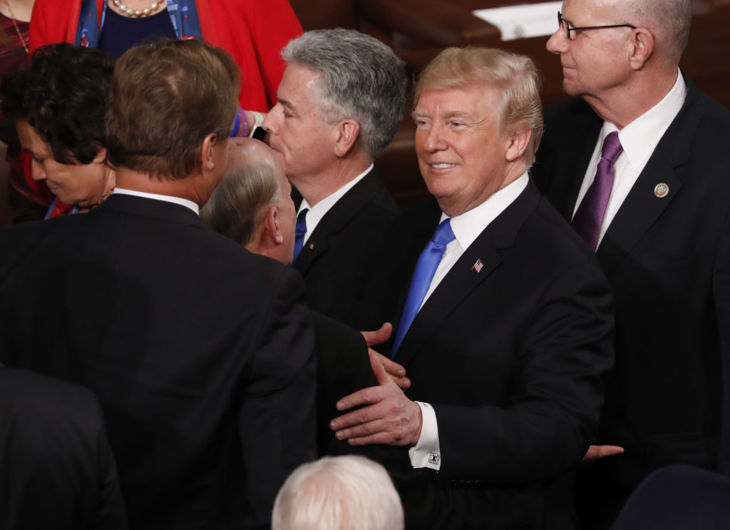 U.S. President Donald Trump (R) talks with members of Congress as he departs after delivering his State of the Union addre...