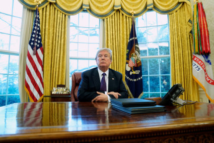 U.S. President Donald Trump sits at his desk after signing directives to impose tariffs on imported washing machines and solar panels in the Oval Office at the White House in Washington, U.S., January 23, 2018. REUTERS/Jonathan Ernst - RC165DD26990