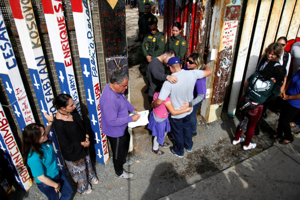 U.S. Border patrol agents open a single gate to allow families to hug and talk along the Mexico and U.S border in Tijuana,...