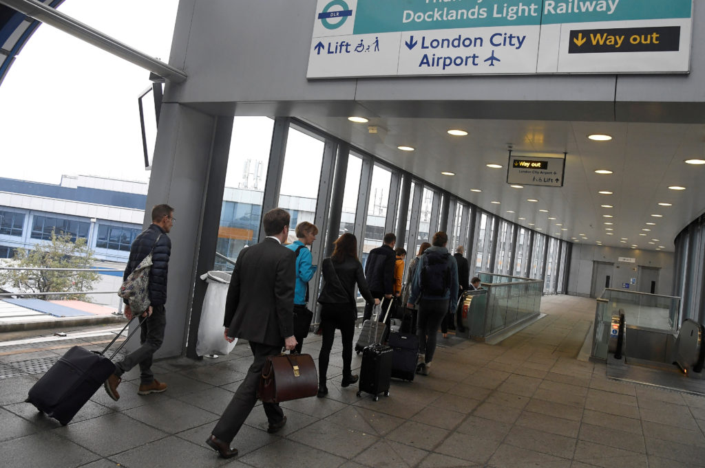 Passengers alight from a train to enter City Airport in London. Photo by Toby Melville/Reuters