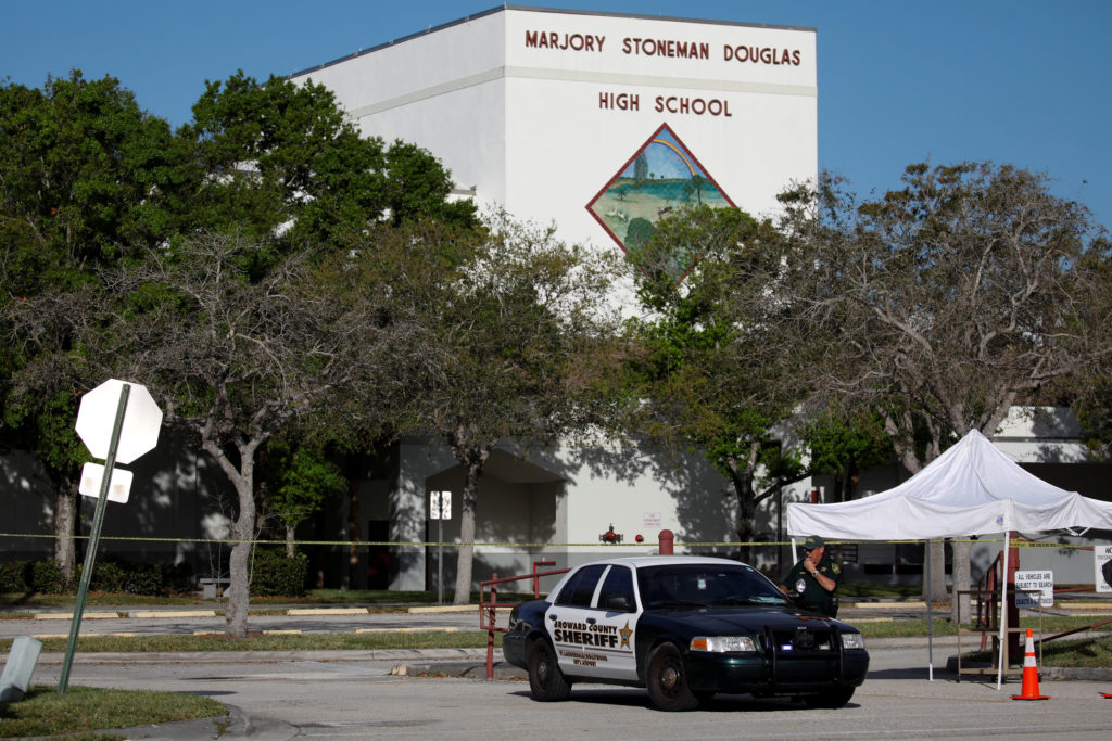 A police officer Jamie Rubenstein stands guard in front of the Marjory Stoneman Douglas High School, after the police secu...