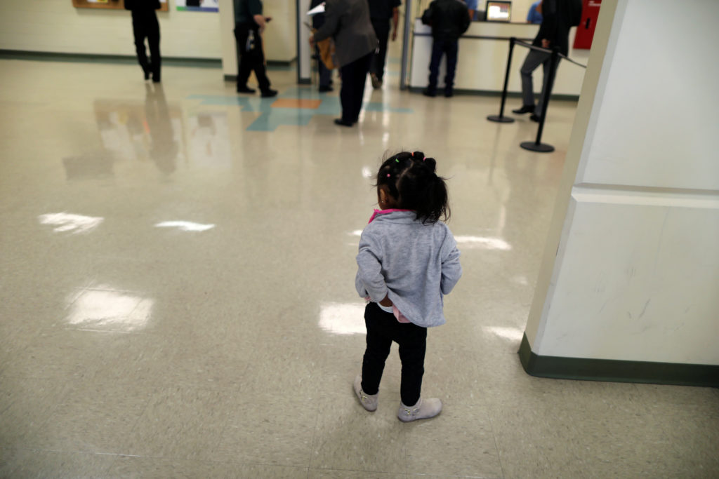 A girl waits with visitors in the lobby of the Adelanto immigration detention center, which is run by the Geo Group Inc (G...