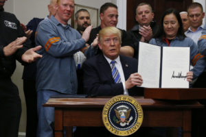 President Donald Trump holds up a proclamation during a White House ceremony to establish tariffs on imports of steel and aluminum at the White House in Washington, D.C. Photo by Leah Millis/Reuters