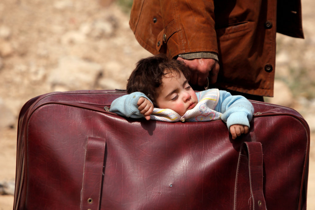 A child sleeps in a bag in the village of Beit Sawa, Eastern Ghouta, in Syria on March 15. Thousands are fleeing since aer...