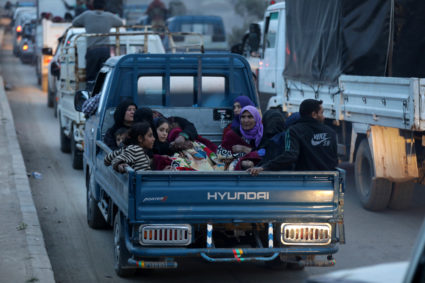 Kurdish civilians sit at the back of a truck in Afrin, Syria. Photo by Khalil Ashawi/Reuters
