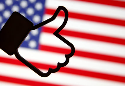 A 3D-printed Facebook Like symbol is displayed in front of a U.S. flag in this illustration taken, March 18, 2018. Photo by Dado Ruvic/Reuters Illustration