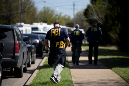 FBI agents walk towards a crime scene on Mission Oaks Boulevard following an explosion in Austin, Texas. Photo by Sergio Flores/Reuters