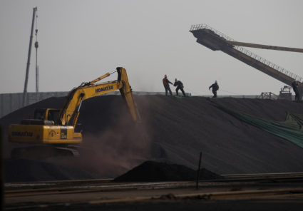 FILE PHOTO: Workers work on a pile of iron ore at a steel factory in Tangshan, Hebei province, China November 3, 2015. REUTERS/Kim Kyung-Hoon/File Photo - RC18ECDC6D40