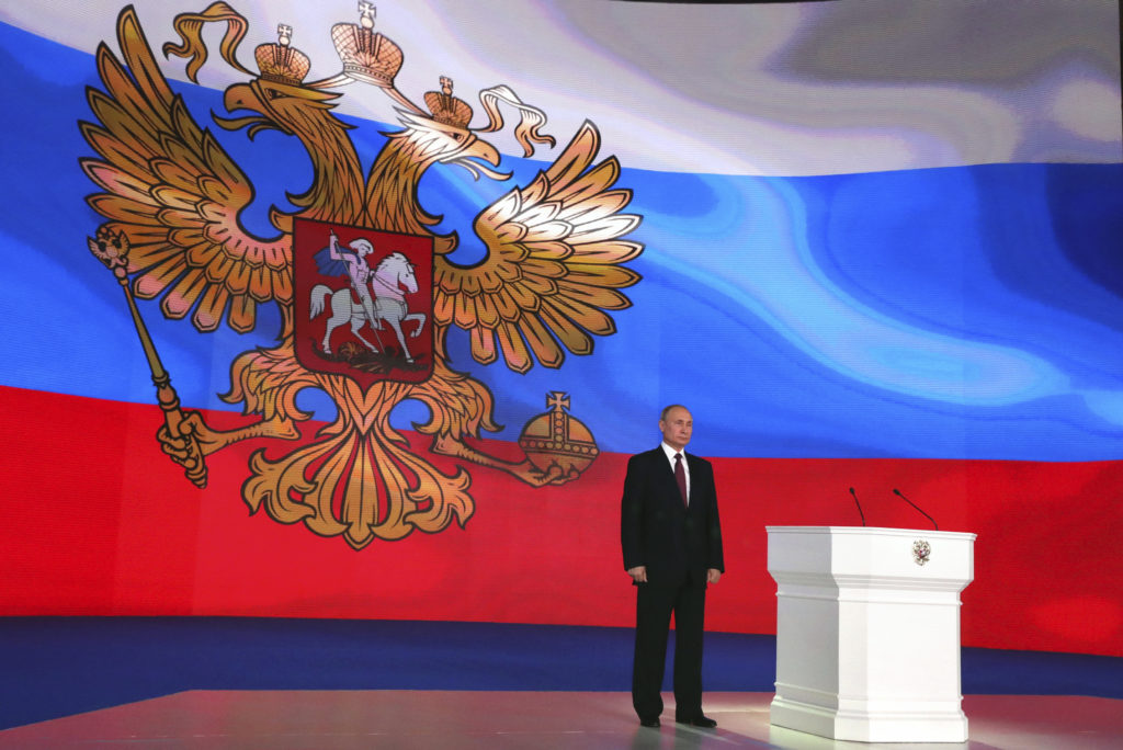 Russian President Vladimir Putin stands on the stage as he addresses the Federal Assembly, including the State Duma parlia...