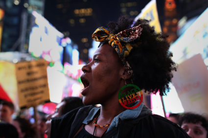 A protester wearing a "Black Lives Matter" earring chants slogans as she marches in Times Square in the Manhattan borough of New York City, during a protest against the death of Stephon Clark in Sacramento, California, U.S. March 28, 2018. REUTERS/Gabriela Bhaskar NO RESALES. NO ARCHIVES. - RC1C1A2FAFC0