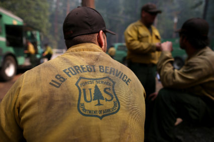 GROVELAND, CA - AUGUST 25: U.S. Forest Service firefighters take a break from battling the Rim Fire at Camp Mather on August 25, 2013 near Groveland, California. The Rim Fire continues to burn out of control and threatens 4,500 homes outside of Yosemite National Park. Over 2,000 firefighters are battling the blaze that has entered a section of Yosemite National Park and is currently 7 percent contained. (Photo by Justin Sullivan/Getty Images)