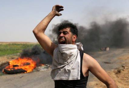 A Palestinian shouts during clashes along the Israel border with Gaza ahead of a protest in a tent city, demanding to return to their homeland, in the southern Gaza Strip March 29, 2018. REUTERS/Ibraheem Abu Mustafa