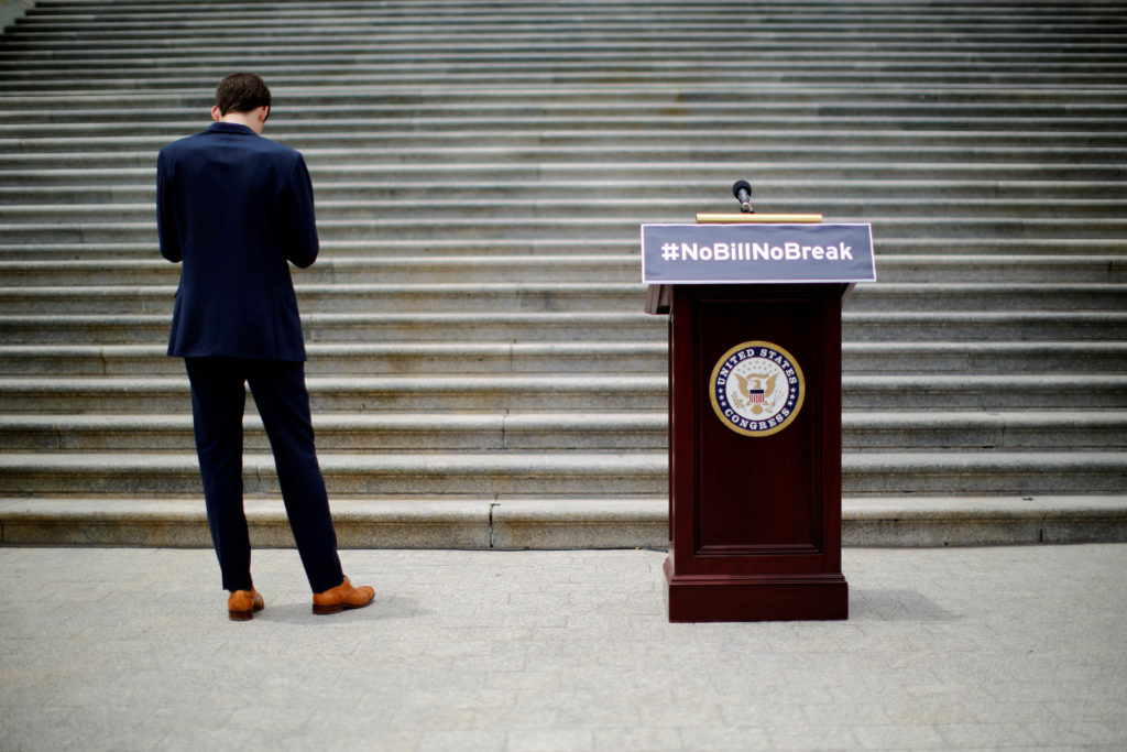 A staff stands next to a podium which reads "#NoBillNoBreak" prior to a news conference by U.S. House Minority Leader Nanc...